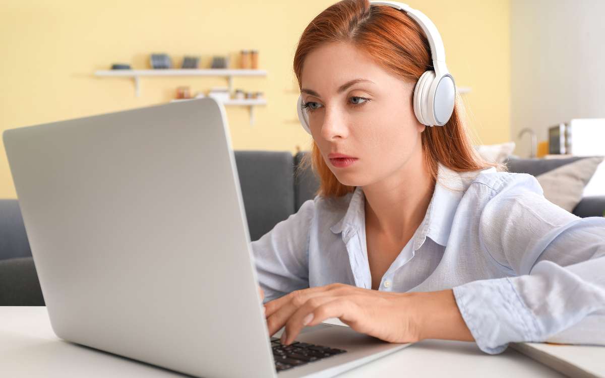 How to Become a Transcriptionist_ Step by Step Guide Featured Image_woman using laptop with headphone.