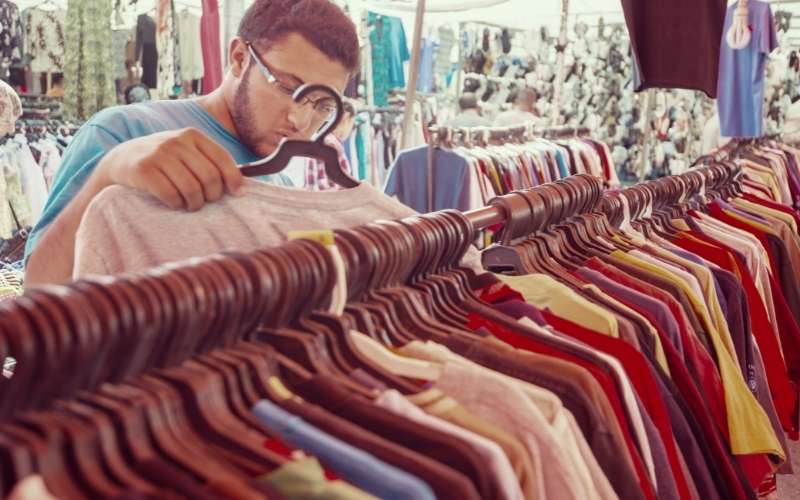 young man buying in second hand store