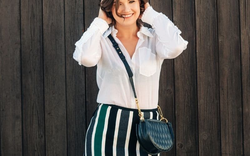 Photo of a woman standing with a cross body bag