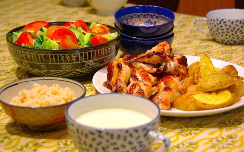 Photo of foods on plates and a cup with milk on a table