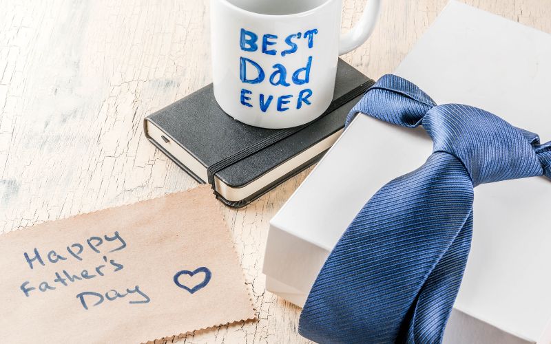 A white mug with texts that say Best Dad Ever , a gift and a card 